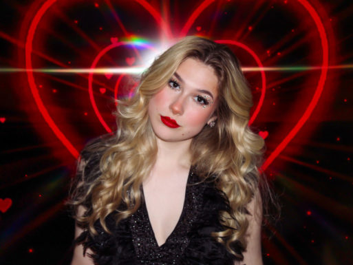Lenox Monroe standing in front of red neon hearts